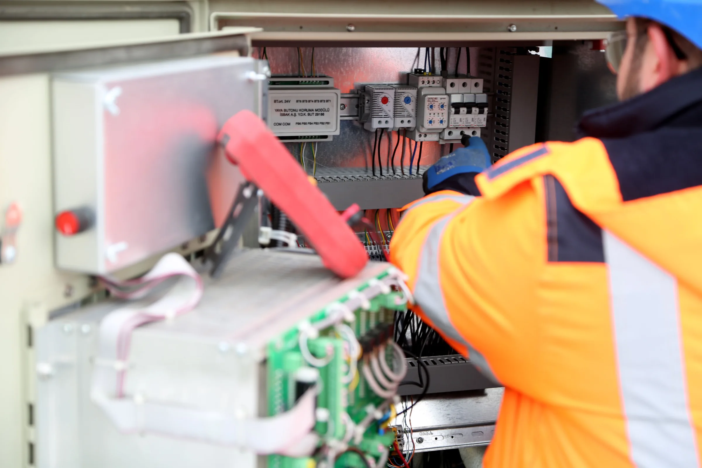 Commercial electrician working on an electrical control panel